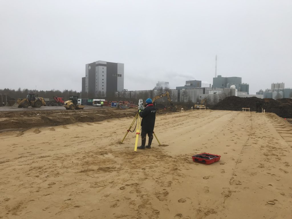 Landinspektør med totalstation ved Arla Arinco Videbæk til bygningsafsætning.
