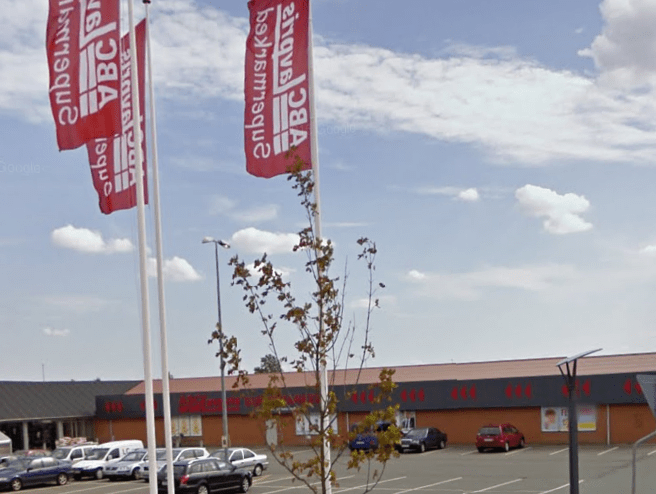ABC butik i Tarm med flag, biler og parkeringsplads