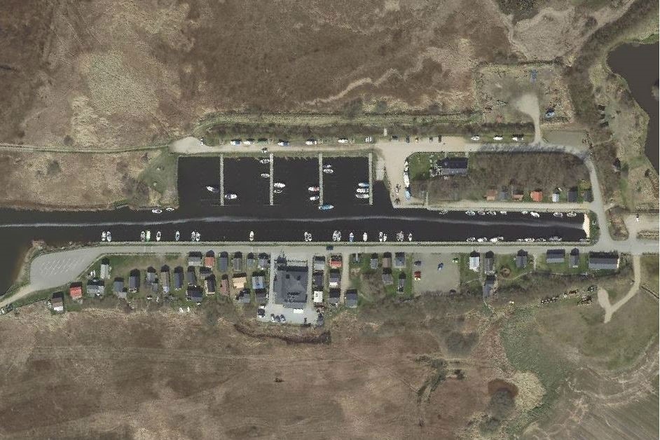 Luftfoto af Stauning Havn og omegn, der viser marina, huse og infrastruktur.