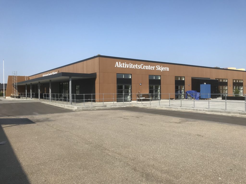 AktivitetsCenter Skjern bygning, med nye udendørsarealer og fortov, set fra parkeringsplads